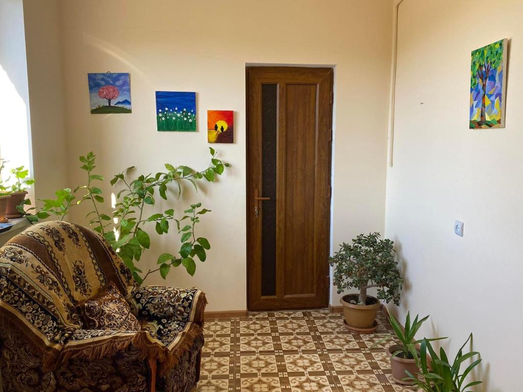 una stanza con una sedia, piante e una porta di Rural Treasure a Garni