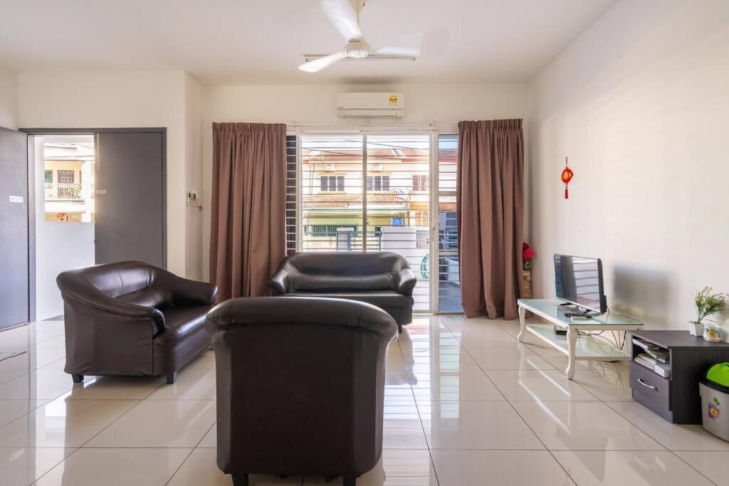 a living room with two leather chairs and a table at COCONUT HOMESTAY Tanjong Karang Sekinchan Kuala Selangor in Kampong Sungai Kajang