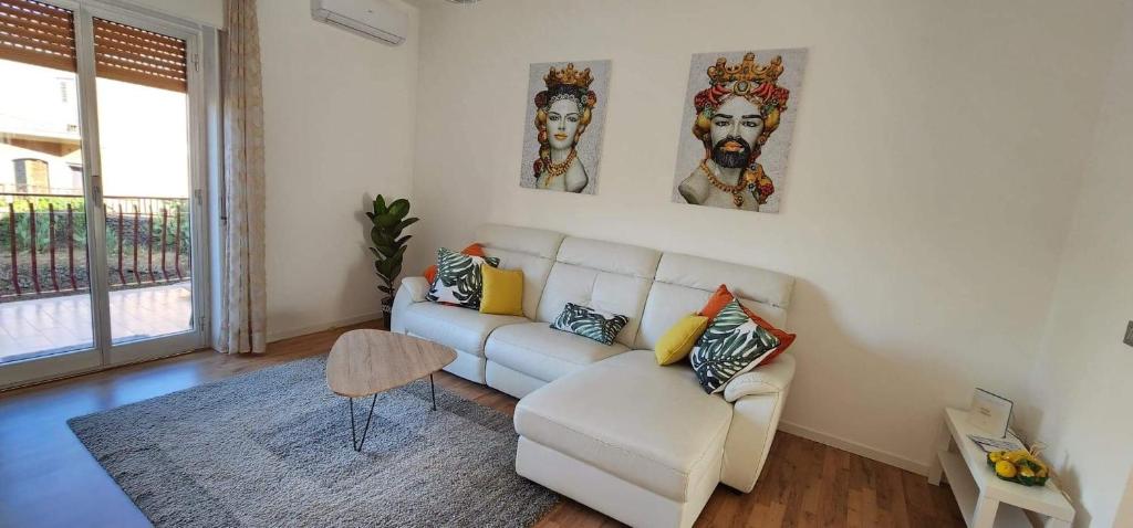 a living room with a white couch and a chair at Appartamento Agrumi in Linguaglossa