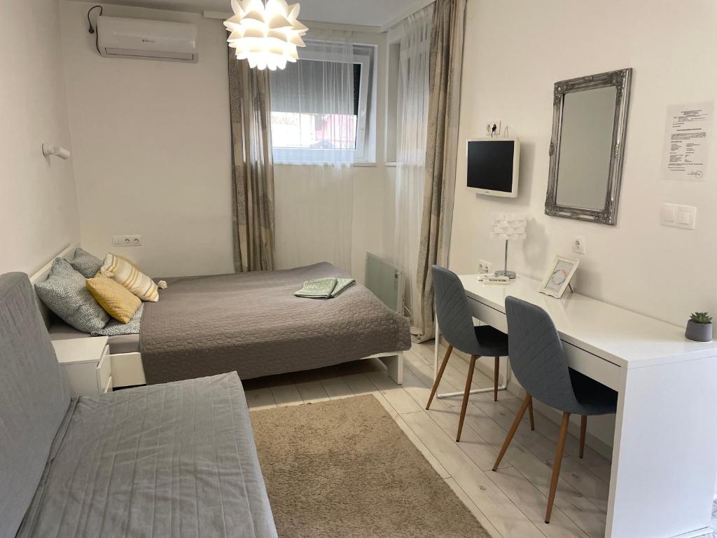 1 dormitorio pequeño con 1 cama, mesa y sillas en Sunrise Apartment, en Hajdúszoboszló