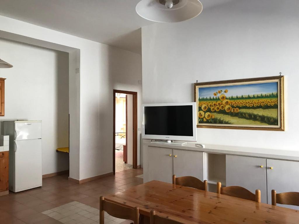 a living room with a table and a flat screen tv at Casa Vacanze in Santa Maria di Castellabate