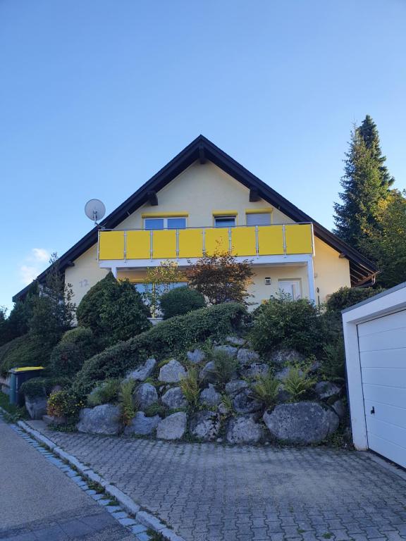 a house with a yellow sign on the side of it at Ferienhaus Sonnengelb im Herzen des Schwarzwaldes in Schönwald
