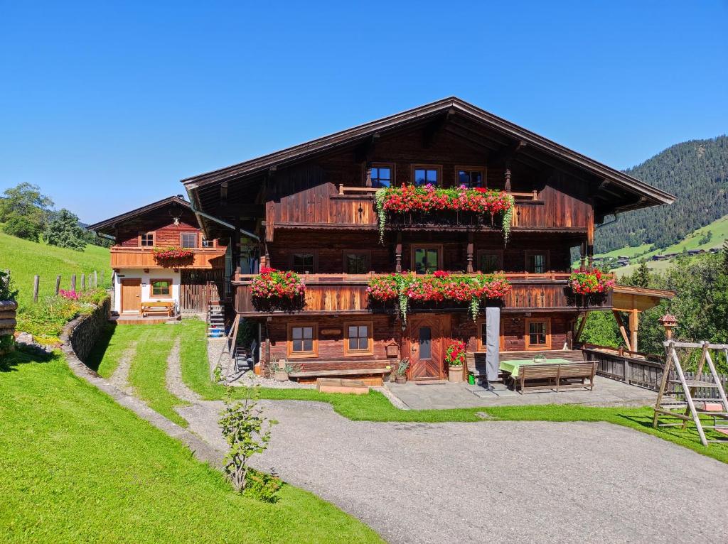 a large wooden house with flower boxes on it at Ferienwohnungen Schneiderhäusl in Alpbach