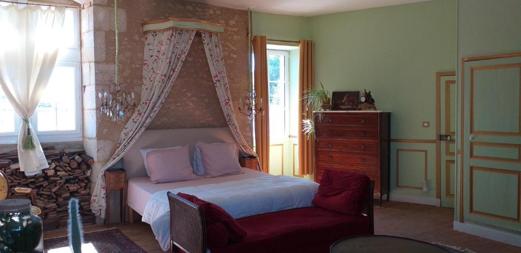 een slaapkamer met een bed, een stoel en een raam bij Chambre Louis XVI au Château de Champagne-Mouton in Champagne-Mouton