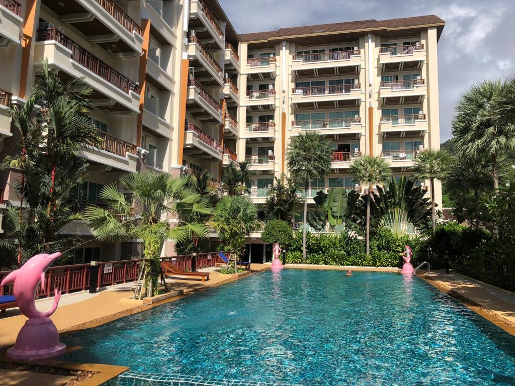 a swimming pool in front of a large building at Phuket villa best location pool view in Patong Beach