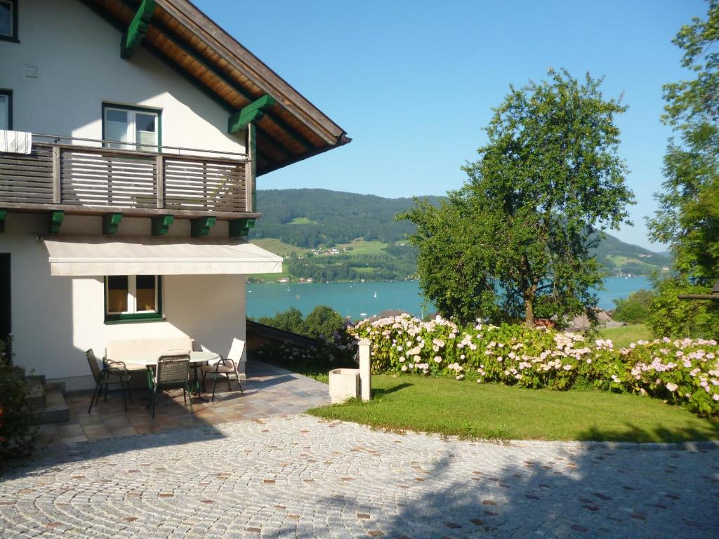 a house with a patio and a view of a lake at Ferienwohnung Schwarzindien in Mondsee