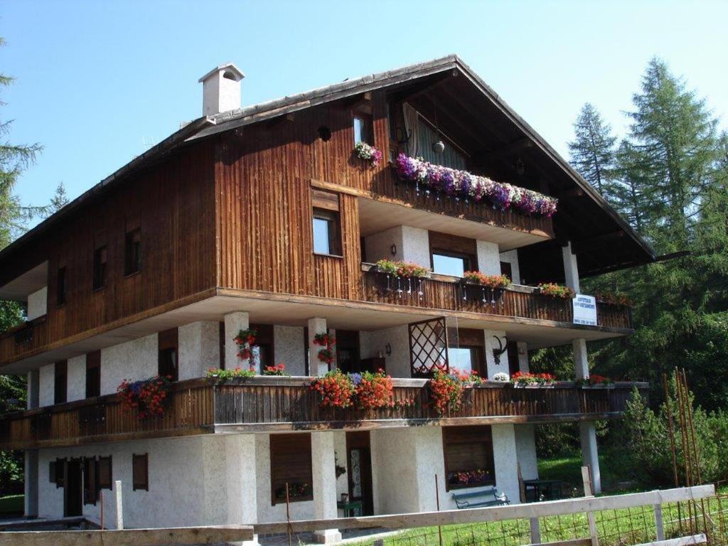un bâtiment avec des fleurs sur ses balcons dans l'établissement Villa Pocol - Stayincortina, à Cortina dʼAmpezzo