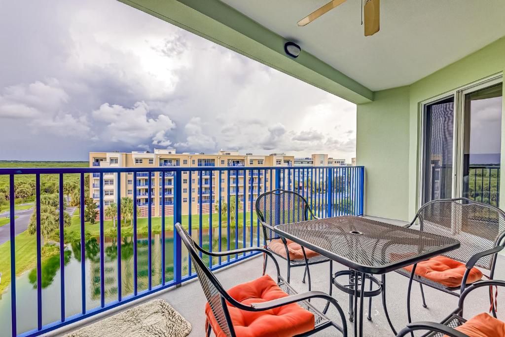 a balcony with a table and chairs and a view at Oceanwalk Suite in New Smyrna Beach