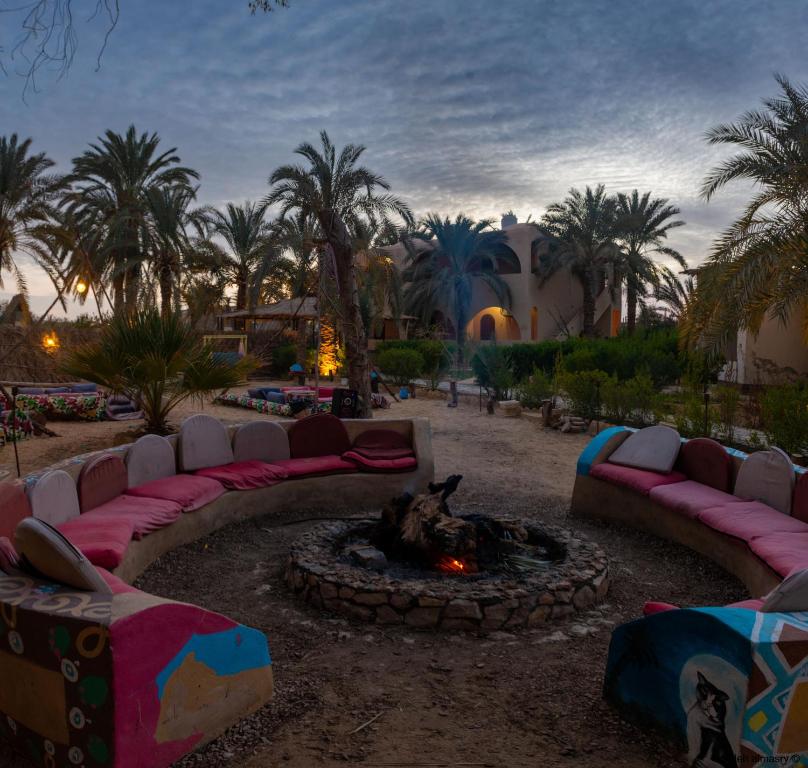 un ensemble de canapés assis autour d'un foyer extérieur dans l'établissement Seliyaa Siwa Inn Hotel, à Siwa