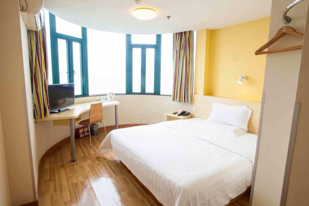 a bedroom with a bed and a desk and a television at 7Days Inn Hengyang West Lake Park in Hengyang