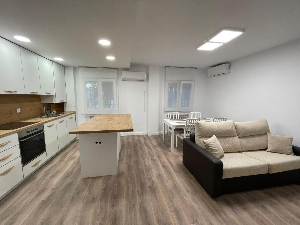 cocina y sala de estar con sofá y mesa en Piso centro de valdemoro, en Valdemoro