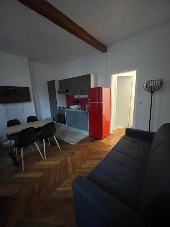 a living room with a couch and a red refrigerator at Appartement au centre de Vincennes in Vincennes