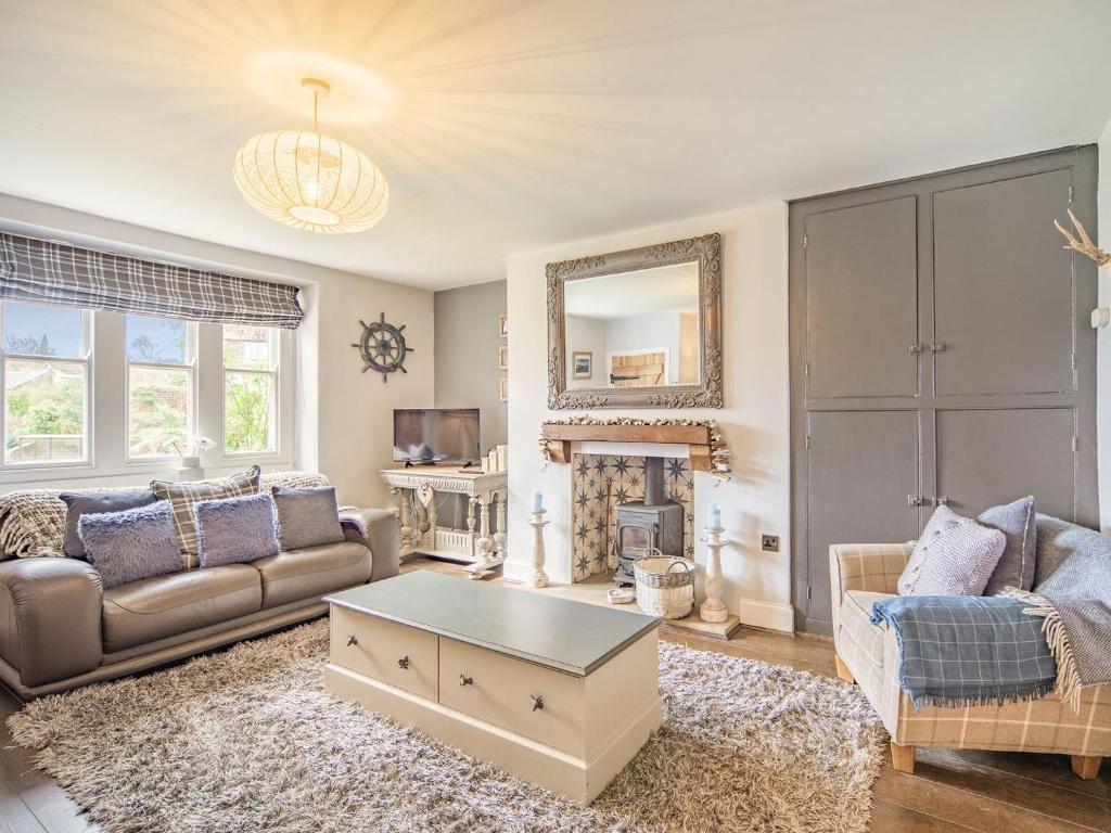 a living room with a couch and a coffee table at Cherrytree Cottage in Chatton