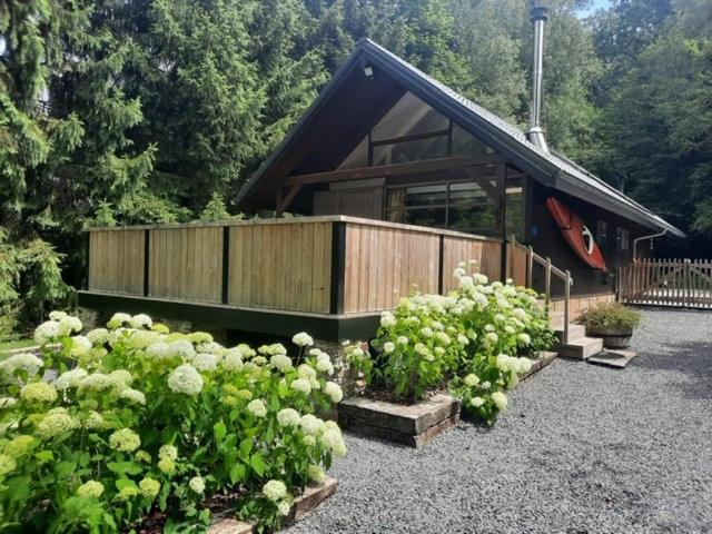 a house with a bunch of flowers in front of it at Chalet Bord De L'eau in Bièvre