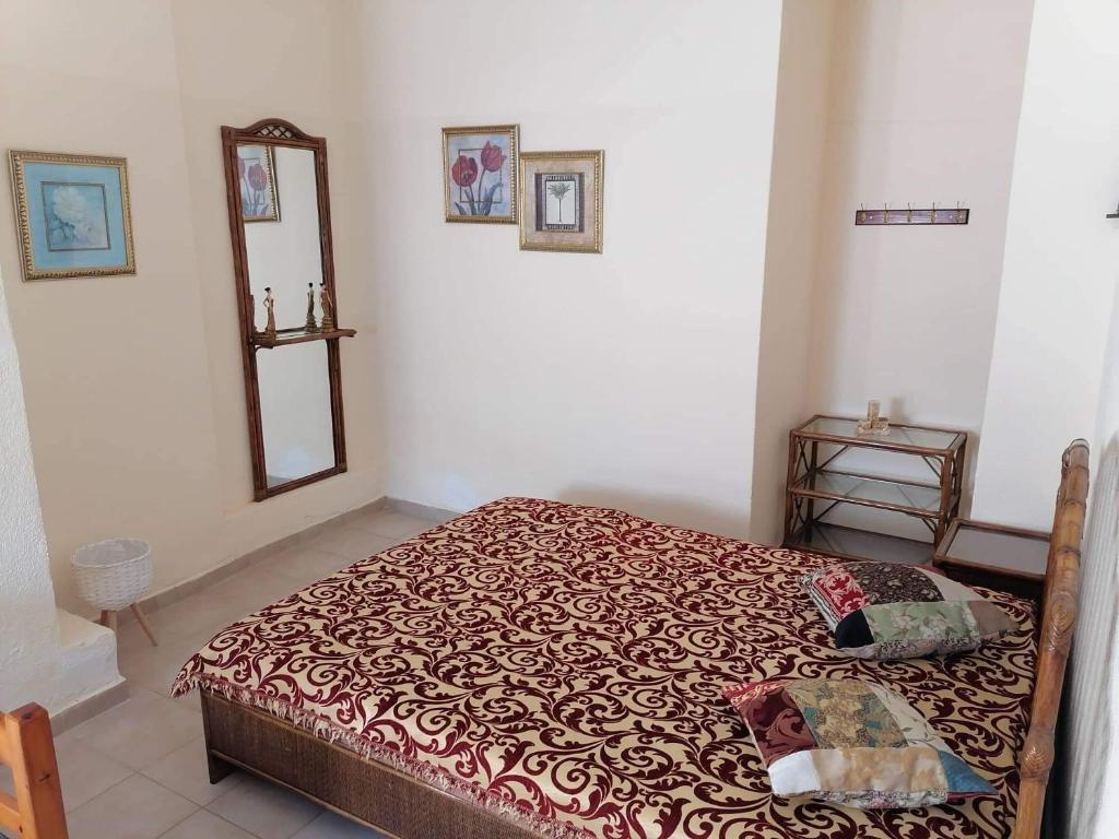 una camera da letto con un letto e uno specchio a parete di Beautiful apartment ANAIS near the sea a Agia Triada
