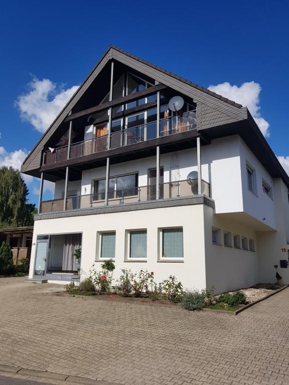 a large white house with a balcony at Ferienwohnung Silk in Niederkrüchten