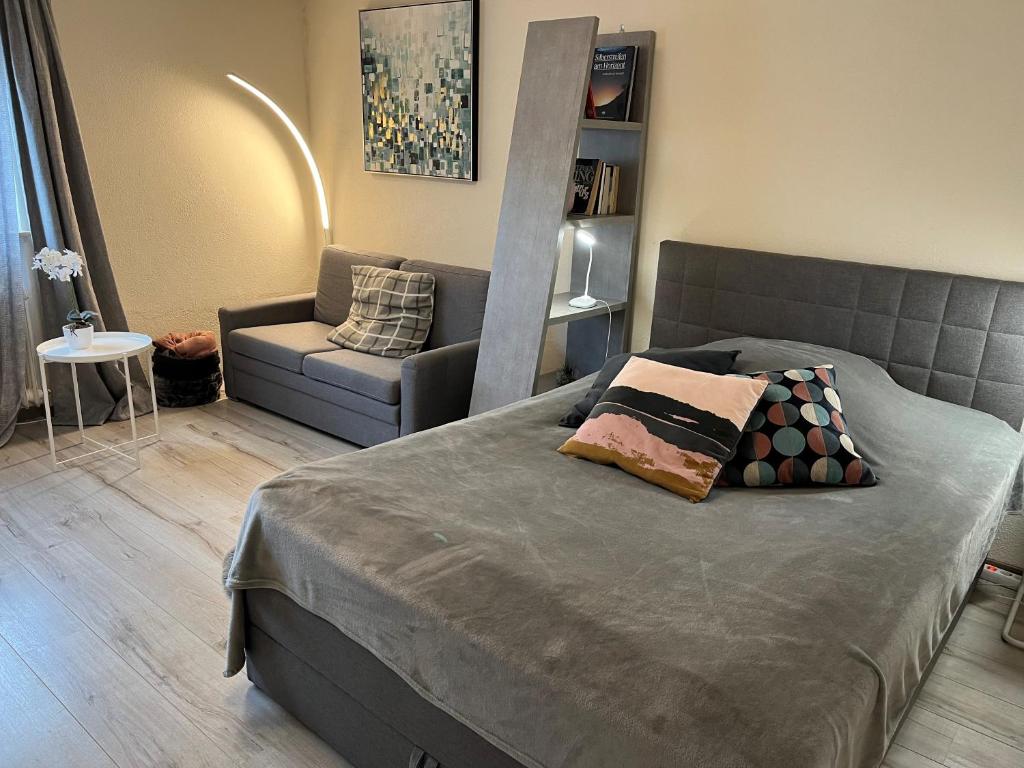 a bedroom with a bed and a couch and a chair at Alice Apartment Wackernheim in Ingelheim am Rhein