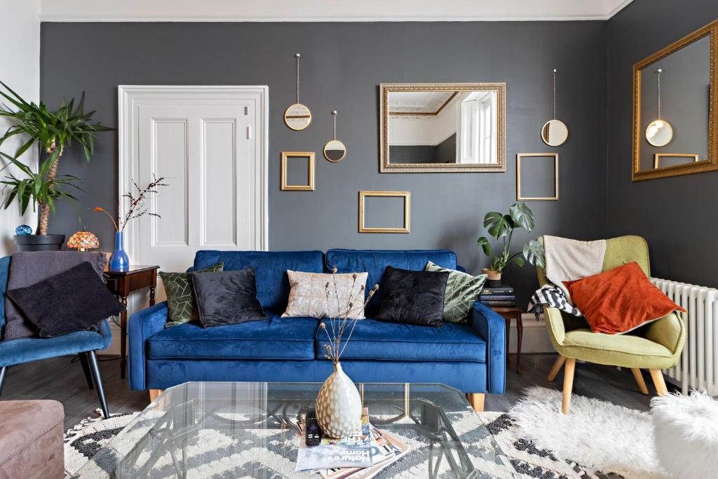 a living room with a blue couch and chairs at Beach access, Modern & Spacious 2 bed Apartment By The Sea, free parking, wifi, netflix in Teignmouth