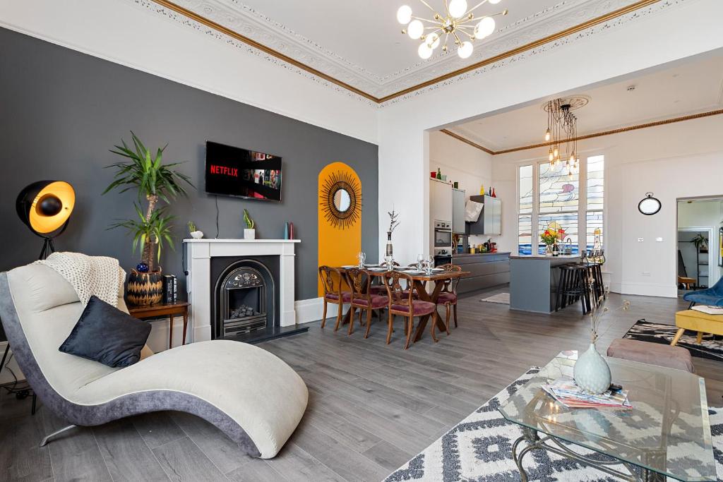 a living room with a fireplace and a dining room at Beach access, Modern & Spacious 2 bed Apartment By The Sea, free parking, wifi, netflix in Teignmouth