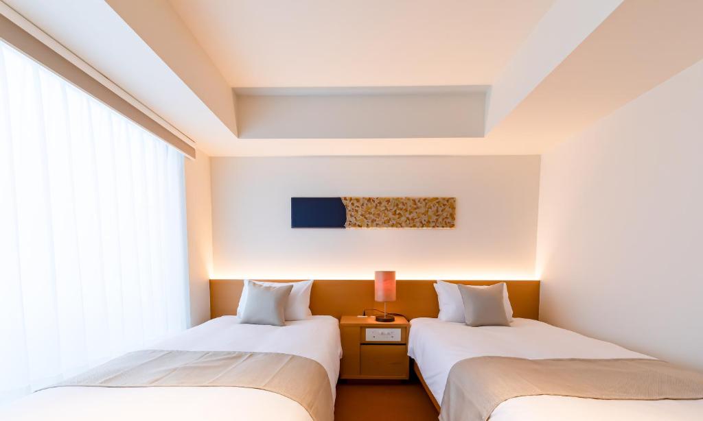 Postel nebo postele na pokoji v ubytování HOTEL RINGS KYOTO