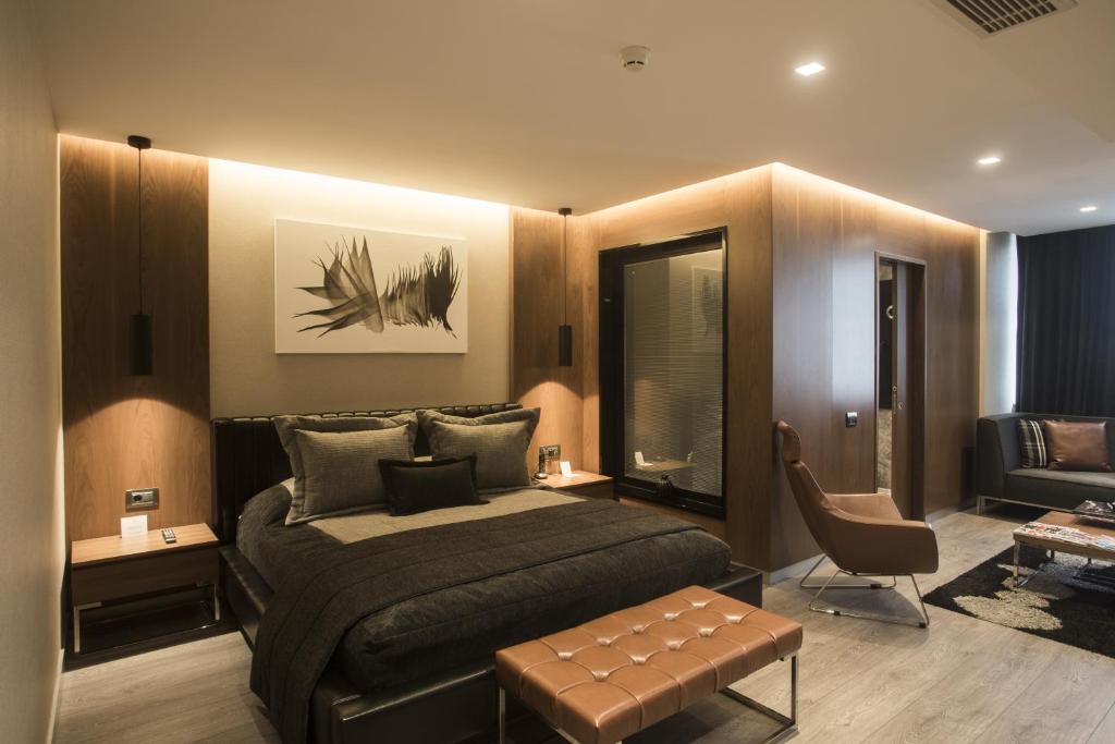 - une chambre avec un lit, une chaise et un canapé dans l'établissement Zeniva Hotel, à Izmir