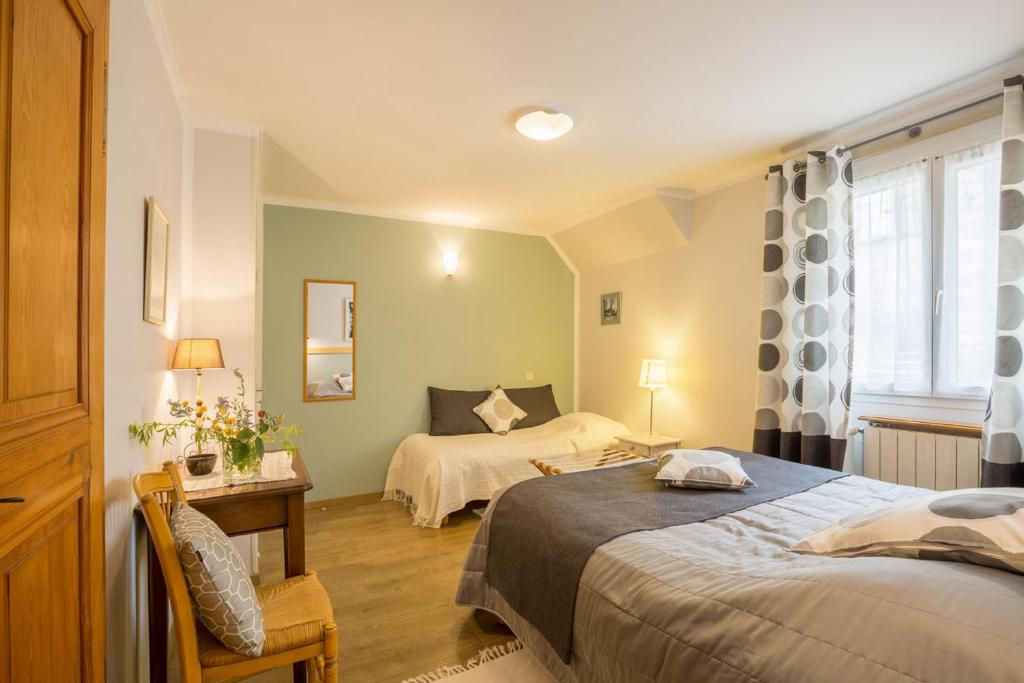 a bedroom with two beds and a desk and a window at CHAMBRES D&#39;HOTES 2 à 4p ou GITE DE GROUPE 15p, 7 ch, 6 sdb, parc et salle de réception in Villeneuve-de-Berg