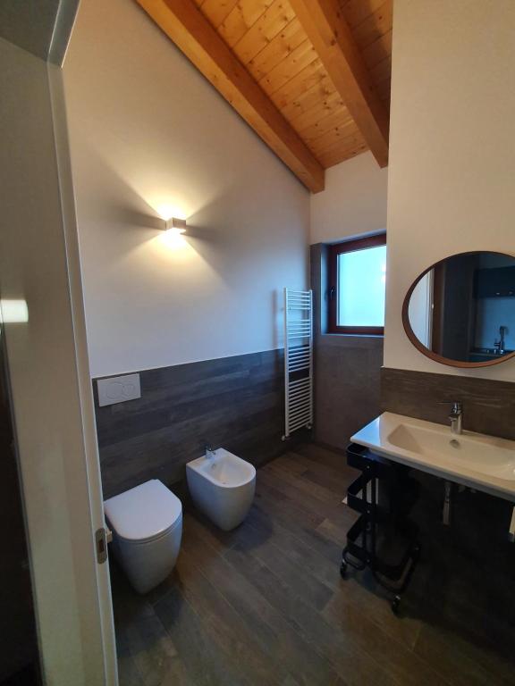 a bathroom with two sinks and a toilet and a mirror at Agriturismo Budin in Sgonico