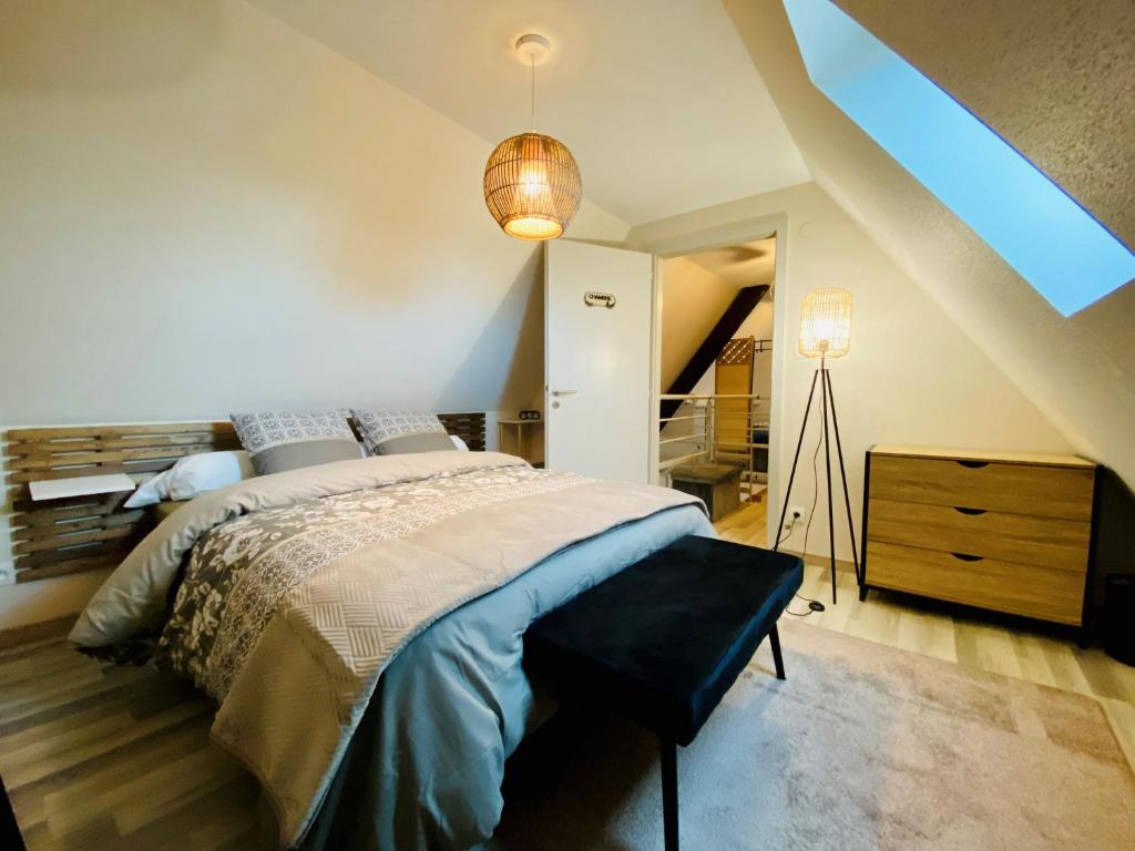 ein Schlafzimmer mit einem großen Bett und einer Lampe in der Unterkunft L'Envolée Alsacienne - Magnifique appartement en duplex in Ostheim