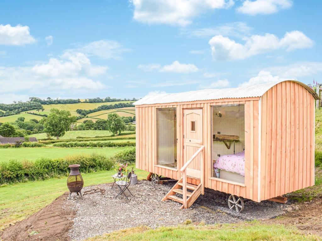 ein winziges Holzhaus auf einem Feld in der Unterkunft The Shearers Hut-uk39774 in Trefeglwys