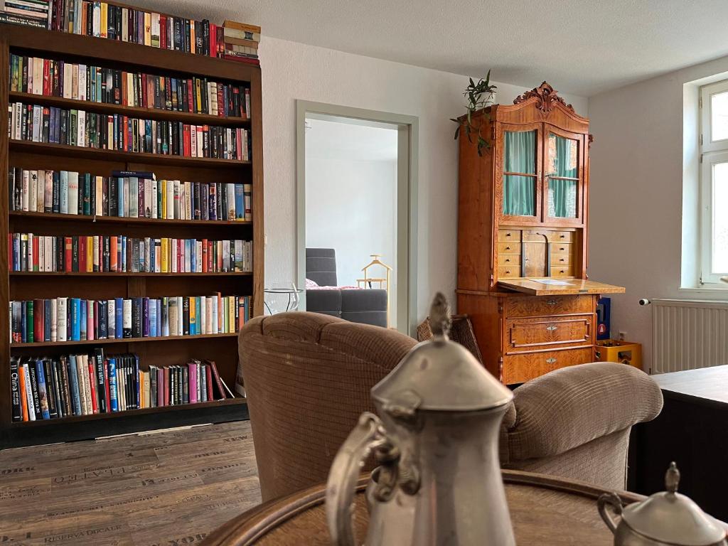 un soggiorno con 2 grandi librerie piene di libri di Ferienwohnung Kaufmannshof a Quedlinburg