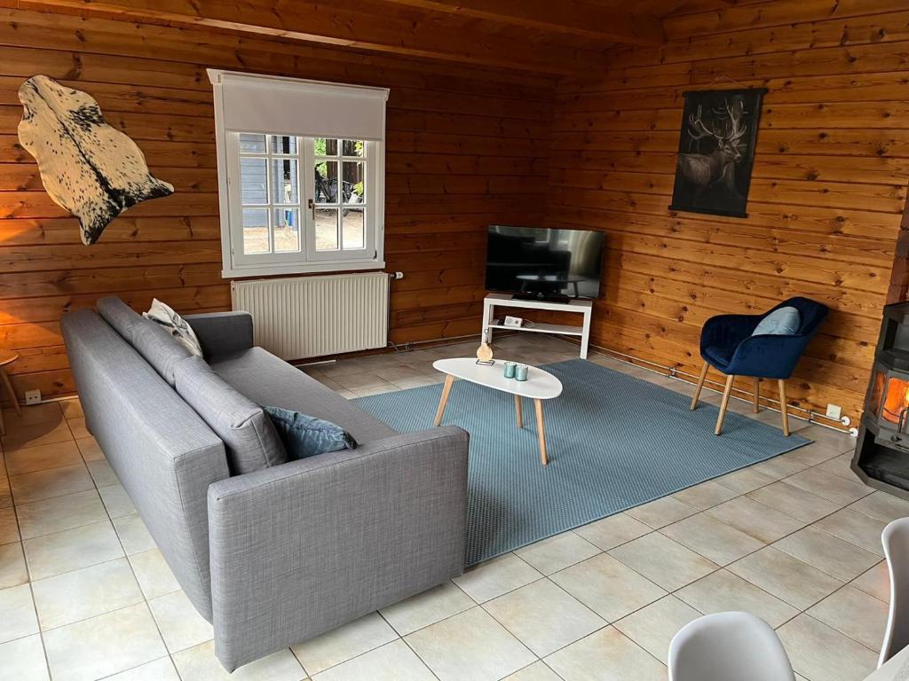 sala de estar con sofá y TV en Veluwse Bungalow en Ermelo