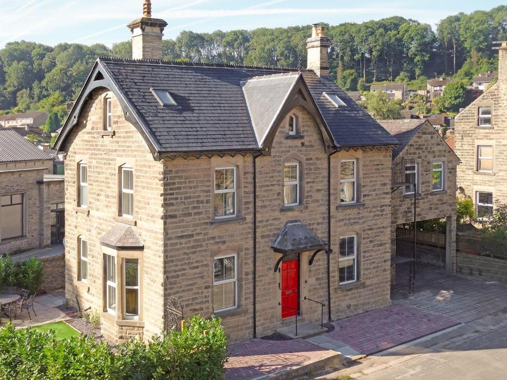 an old brick house with a red door at Haddon Villa in Bakewell