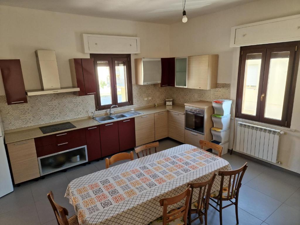 a kitchen with a table and some chairs and a table and a table at Pepe's house , a 1 km dal mare in Isca sullo Ionio