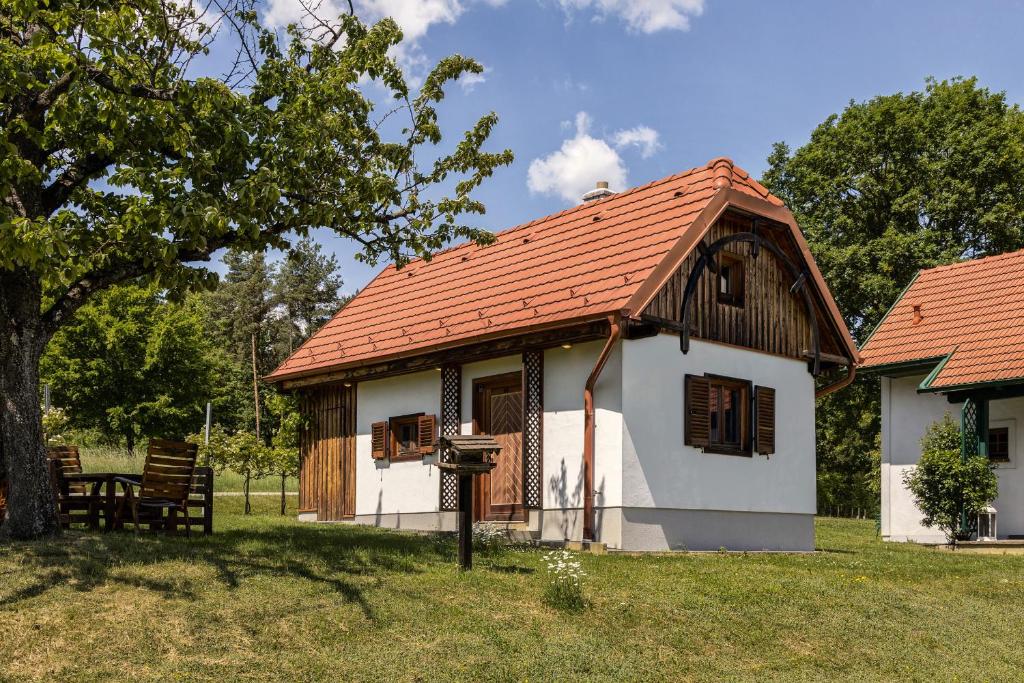 mały biały dom z czerwonym dachem w obiekcie Kellerstöckl Postrumer Weinberg 48 w mieście Kulm im Burgenland