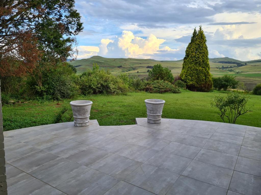 a stone table with two stools on top of it at Burnbrae Farmhouse (6 b/rooms with pool) in Himeville