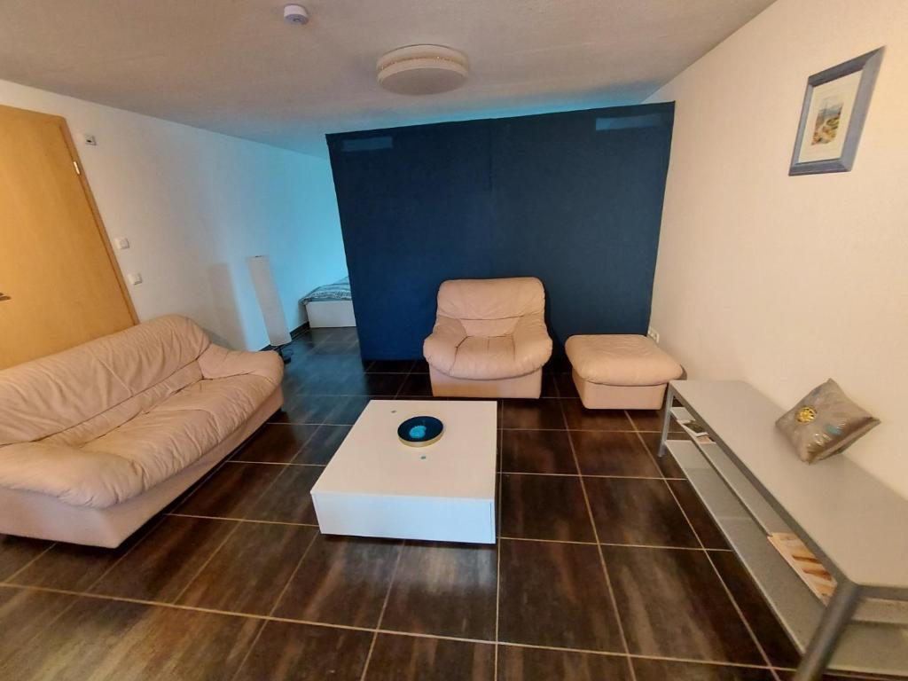 uma sala de estar com um sofá e uma mesa em Lovely Appartment with private patio and private entrance in Luxembourg 60m2 em Saeul