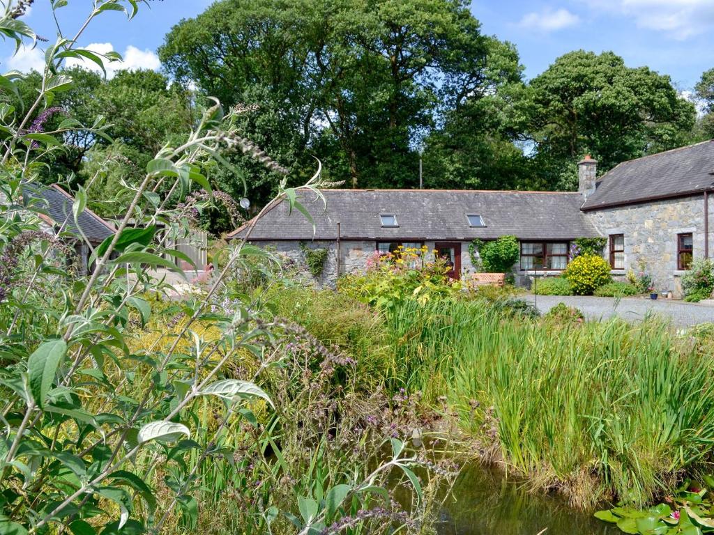 um antigo chalé de pedra com um jardim em frente em Low Cordorcan - Uk5891 em Bargrennan