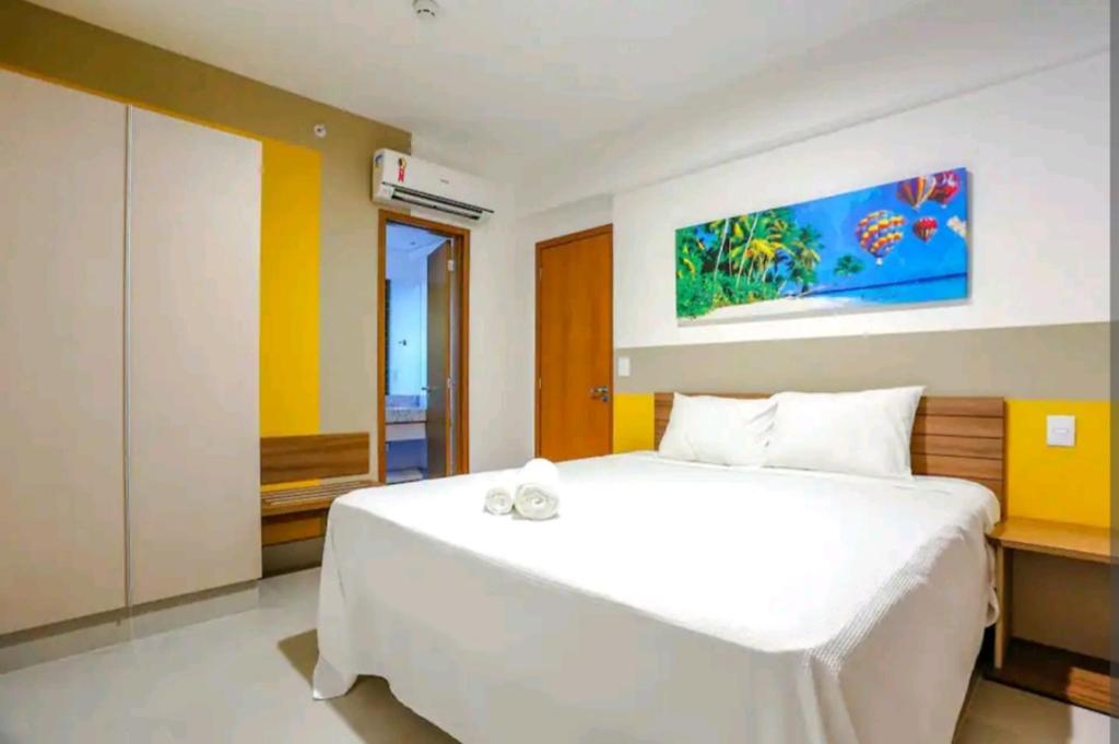 una camera da letto con un letto bianco e un quadro sul muro di Enjoy Olímpia Park Resort - Thermas dos Laranjais a Olímpia