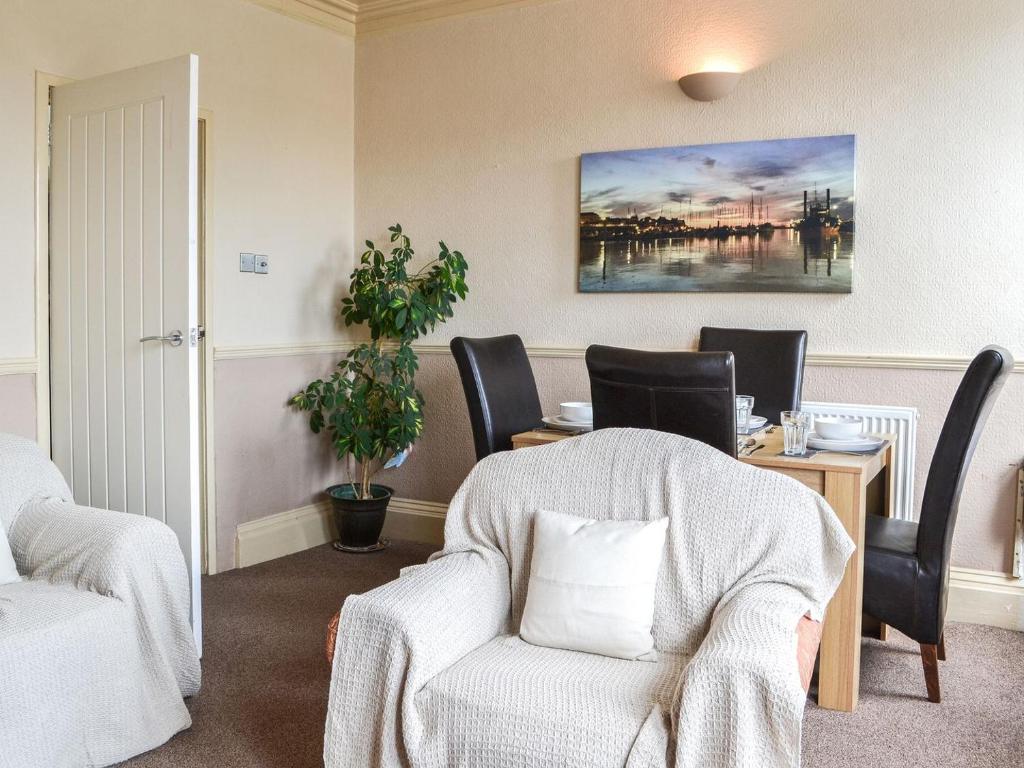 a living room with a chair and a table with at White Rose Apartment in Bridlington