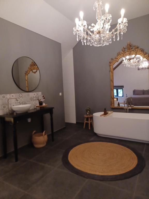 uma casa de banho com uma banheira, um lavatório e um espelho. em Luxe-kamer Bed en Bokes 