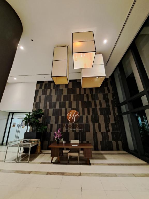 a lobby with a table and chairs and lights at Woodsbury Suites IKEA House Butterworth Penang in Butterworth