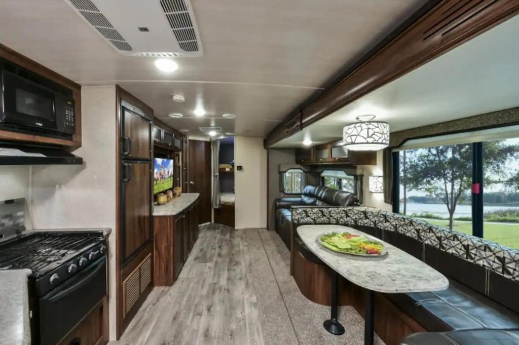 a kitchen and living room in a rv with a table at Heartland North Trail 31' RV in Manchaca