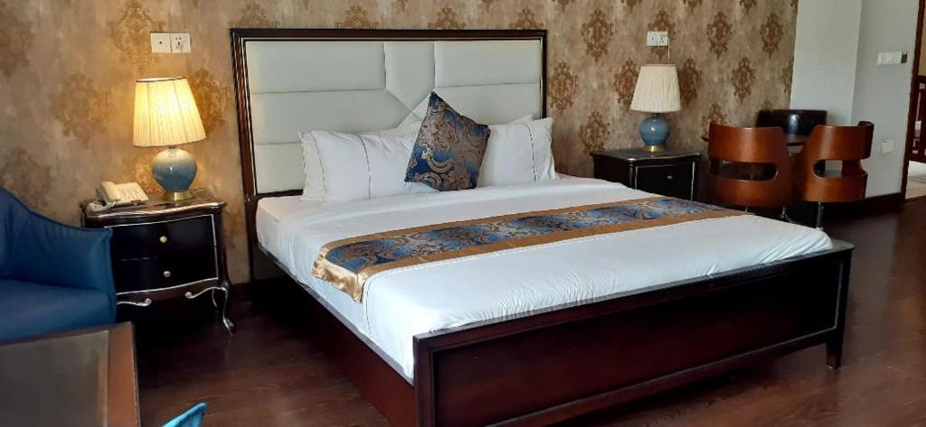 sypialnia z dużym łóżkiem i 2 szafkami nocnymi w obiekcie Swisstel Cottage w mieście Karaczi