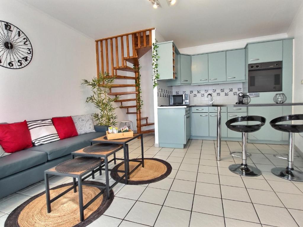 Il comprend un salon avec un canapé et une cuisine. dans l'établissement Duplex Le Cachou : 10 min Aéroport de Roissy CDG - Astérix - Paris, à Moussy-le-Vieux