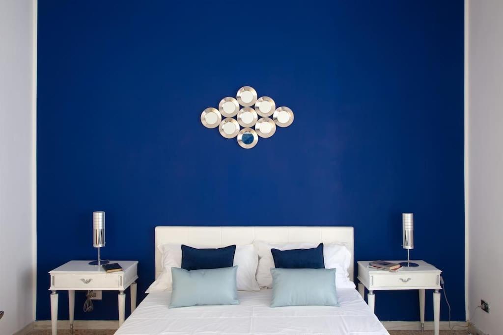 a blue bedroom with a white bed and two tables at Home Bernadette in Rome