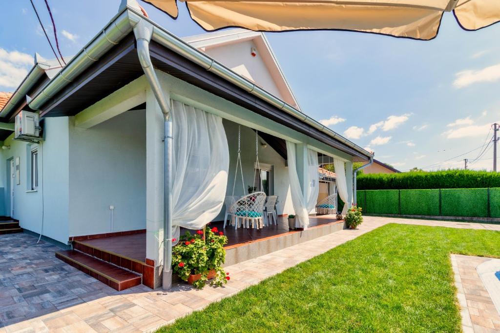 a house with a patio and an umbrella at Green Art House in Kovilovo