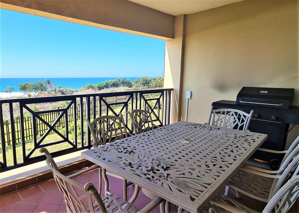 una mesa y sillas en un balcón con vistas al océano en Bondi Beach D, en Shelly Beach
