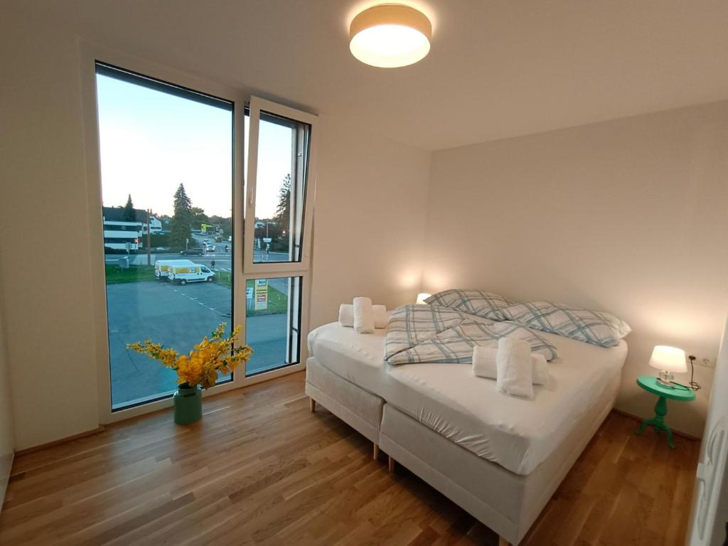 una camera da letto con un letto e una grande finestra di Neu erstellte Wohnung mit Balkon in Hard a Hard