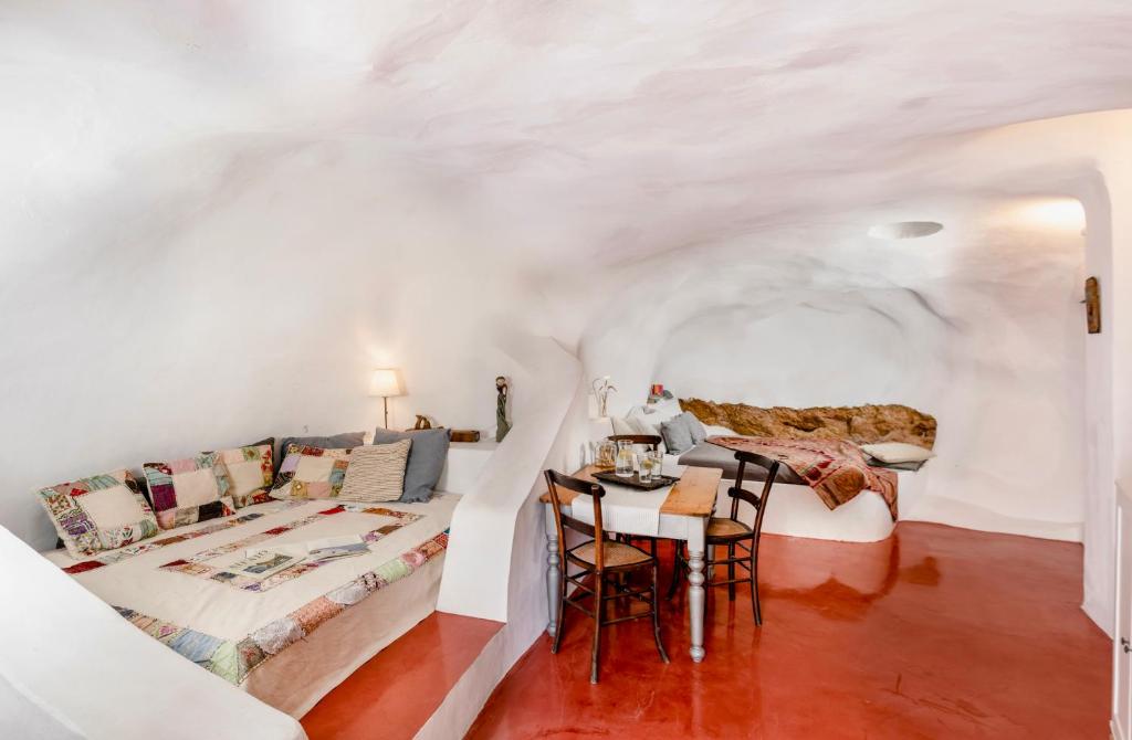 a room with a bed and a table and chairs at Traditional Farmers Caves in Emporio