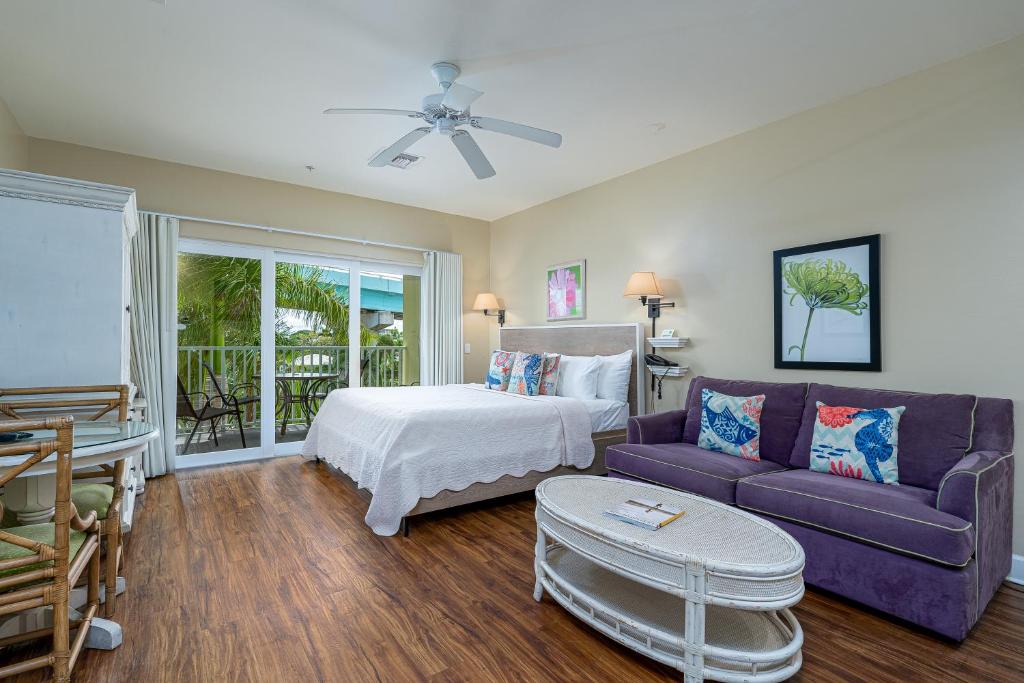 a bedroom with a bed and a purple couch at Harbour House at the Inn 314 in Fort Myers Beach